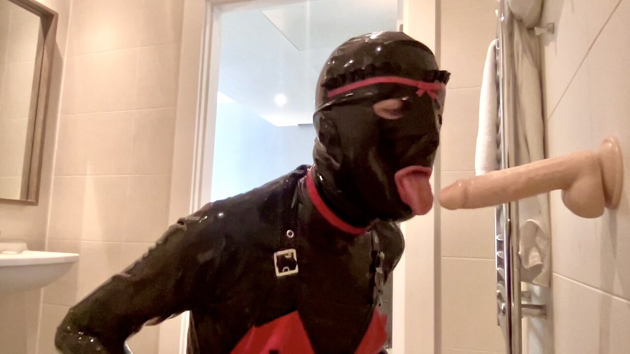 Latex Alice soffia e fa una gola profonda con un dildo mentre è in