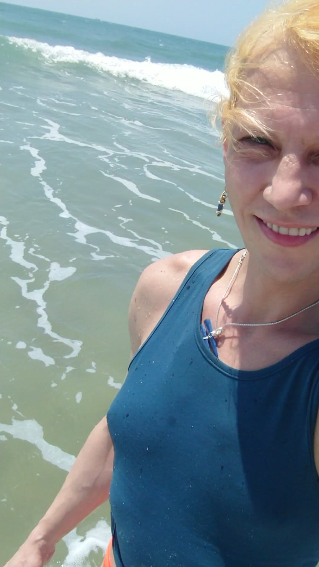 Transgirl, das zum ersten mal im roten höschen und blauen t-shirt im Pazifik schwimmt. Sonne und heißes Wetter genießen. Wetlook-titten im t-shirt.
