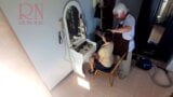 Caméra dans un salon de coiffure nu. Un coiffeur fait se déshabiller une femme pour se couper les cheveux. barbier, nudisme. Caméra 21 snapshot 2