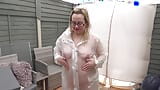 Naked wearing Plastic Transparent Raincoat and White PVC Boots in the freezing Cold outdoors snapshot 1