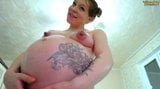 Une fille enceinte de 9 mois avec un gros ventre montre son corps snapshot 18