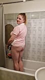 A chubby student girl takes a shower in a pink T-Shirt snapshot 1