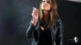 Ragazza calda che fuma in pelle e stivali snapshot 12