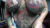 Fortemente tatuada e com piercing, motociclista viúva negra chupa snapshot 9