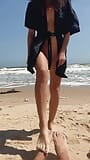La ragazza teenager nuda mostra la figa, le gambe ed i piedi, feticismo del piede, delle gambe sulla spiaggia nudista all'aperto snapshot 15