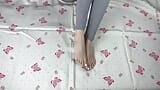 Girl in gray leggings with long legs caresses her feet with a white pedicure snapshot 5