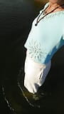 파란 블라우스와 화이트 밀크 바지를 입고 호수에서 수영하는 트랜스 소녀. snapshot 5