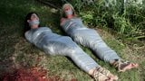 Two girls duct tape mummies outdoors snapshot 4