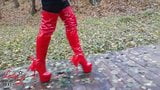 Lady L sexy walking with extreme red boots in forest. snapshot 2