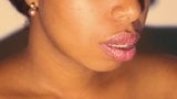 Negrita de labios sexy jugando con su lápiz labial rojo en primer plano snapshot 3