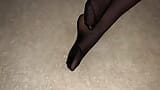 Meisje toont haar sexy voeten in zwarte nylon panty snapshot 5