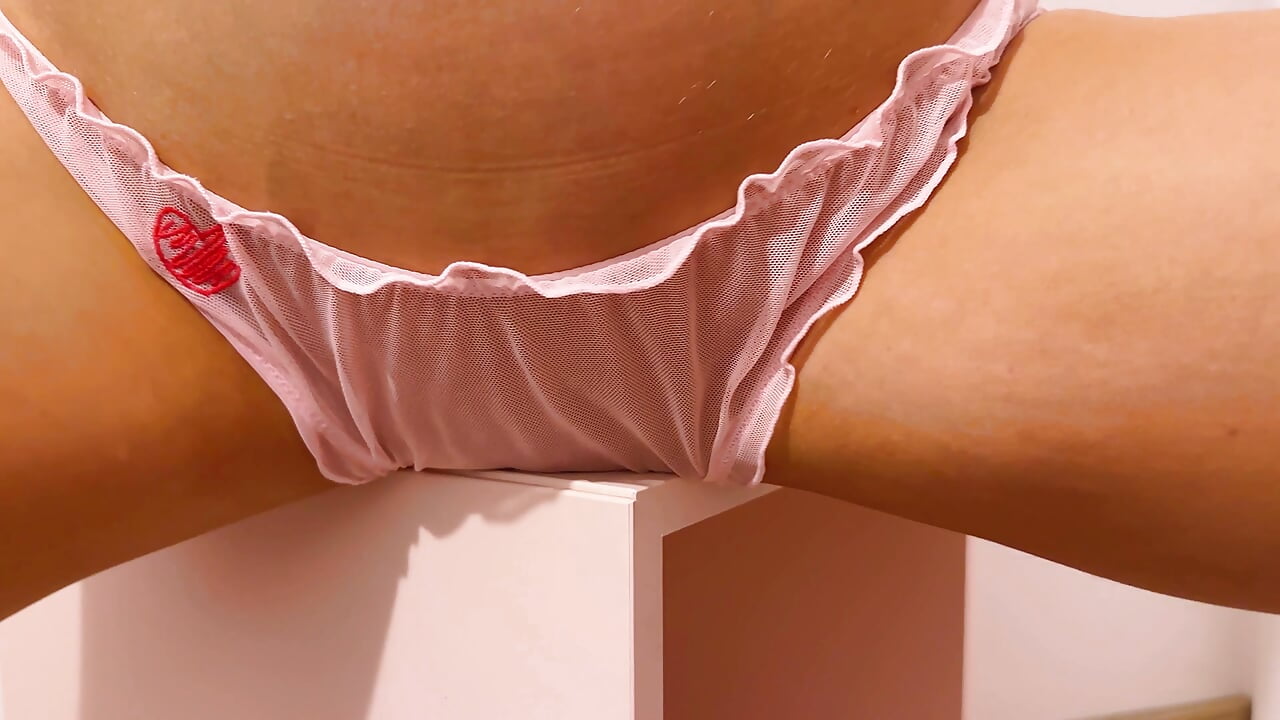 Beauty in pink panties humps pussy against the table corner.