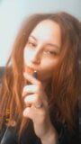 Redhead Asian woman with tattoos blows smoke snapshot 2