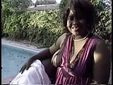 Black slut strokes giant cock with her fat tits in pool chair snapshot 3