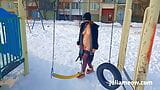 Naked tomboy in a fur coat swings on a swing in winter snapshot 6