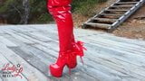 Lady L sexy walking with extreme red boots in forest. snapshot 15