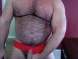 Muskulöser Mann auf roten Speedos snapshot 11