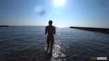 Nude model swims on a public beach in Russia. snapshot 1