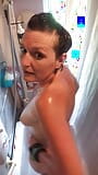 Une MILF sexy masse son corps tatoué, tonique et marqué sous la douche snapshot 4
