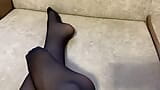 Une fille en collants en nylon noirs caresse ses longues jambes snapshot 14