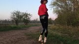 Dans un pantalon en cuir moulant posant en plein air snapshot 2