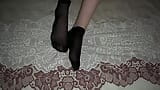 Chica en calcetines de nylon negros acaricia sus piernas snapshot 16