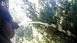 Fetter Schwuler pisst draußen im öffentlichen Park mit starkem Pisstream mit unbeschnittenem kleinem Schwanz. snapshot 2