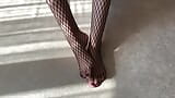 Une fille en collants résille noirs caresse ses jambes snapshot 1