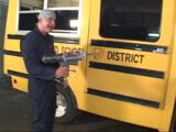 Older dude in uniform of car mechanic tempts young blonde near the school bus snapshot 2