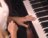 Danni Ashe eet en vingert poesje op een piano snapshot 2