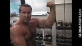 Haariger Bodybuilder muscledaddy, der Muskeln in der Turnhalle biegt snapshot 1