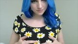 Chica de pelo azul en flores juega con tetas snapshot 3