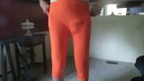 Male slut in skin-tight, bright orange spandex leggings. snapshot 2