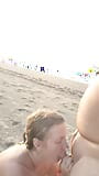 Gorąca para na nagiej plaży cieszy się ręczną robotą w morskim powietrzu. snapshot 1