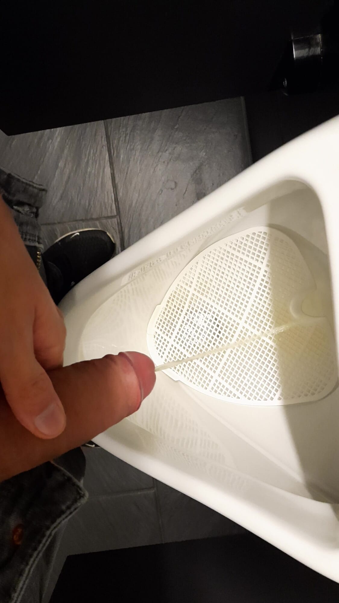 Young boy pissing in public toilet