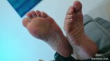Amante muestra las suelas arrugadas y los dedos de los pies en el sofá snapshot 2