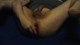 Young man inserts a red buttplug snapshot 7