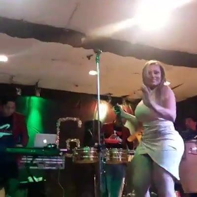Jackie Castañeda cantando con mini vestido