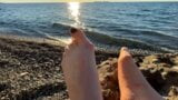 Mestra Lara brinca com os pés e dedos dos pés na praia snapshot 2