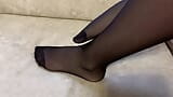 Une fille en collants en nylon noirs caresse ses longues jambes snapshot 13