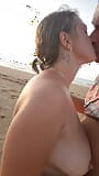 Gorąca para na nagiej plaży cieszy się ręczną robotą w morskim powietrzu. snapshot 2