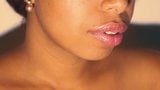 Negrita de labios sexy jugando con su lápiz labial rojo en primer plano snapshot 2