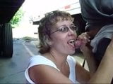 Wanita dewasa mengisap ayam di antara truk di tempat parkir snapshot 14