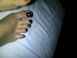 Füße auf schwarzem Lack des Betts snapshot 2