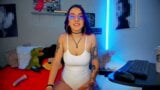 La ragazza colombiana otaku webcamer con i capelli viola e tatuaggi sembra molto sensuale mentre trasmette con un body bianco snapshot 4