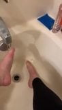 Alexis Black rubs her feet in the bath with leggings snapshot 2