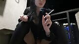 Calda e sexy dominatrice Nika sta fumando una sigaretta sul suo balcone, soffiando il fumo in faccia. snapshot 2