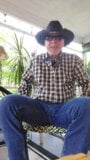 Cowboy -vader pompt pik en knijpt zittend op de achterportiek snapshot 1