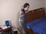 Duct tape mummified girl stands, hops snapshot 5