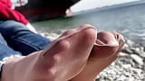 Cute feet in nylon socks and jeans resting on the sunny seashore snapshot 3